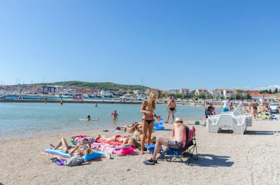 Vodice oblázková pláž s pozvolným vstupem do moře.