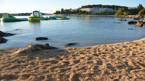 Oblázková pláž v městě Rovinj (beach Lone Bay).