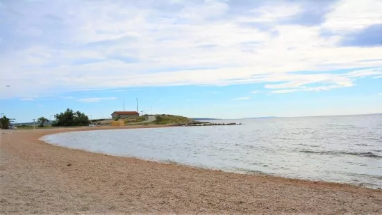 Oblázková pláž v městečku Povljana.