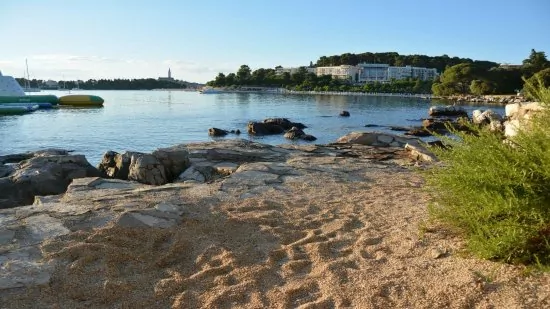 Oblázková pláž ve městě Rovinj (Lone Bay).