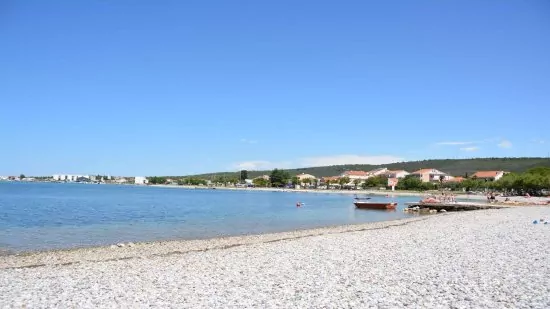 Sukošan - oblázková pláž podél pobřeží.