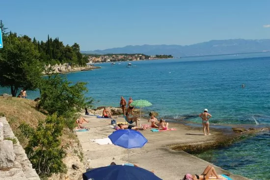 Pobřeží města Crikvenica s menšími plážemi, doplněné o betonová mola.